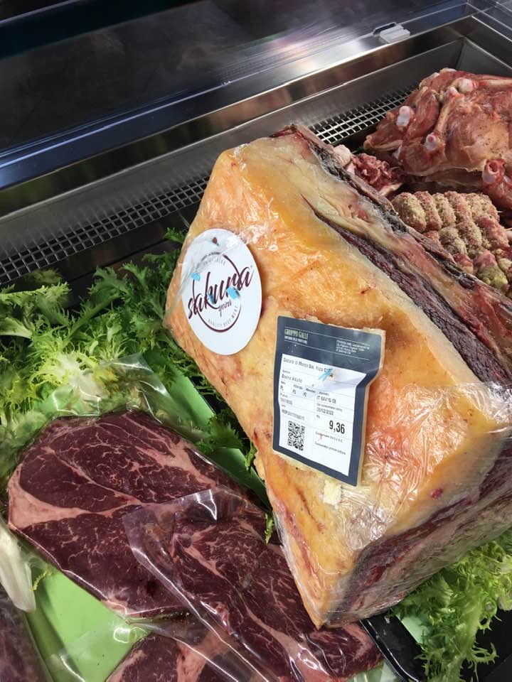 Esposizione della carne: bistecca grande, confezionata, con etichetta; altri tagli visibili.