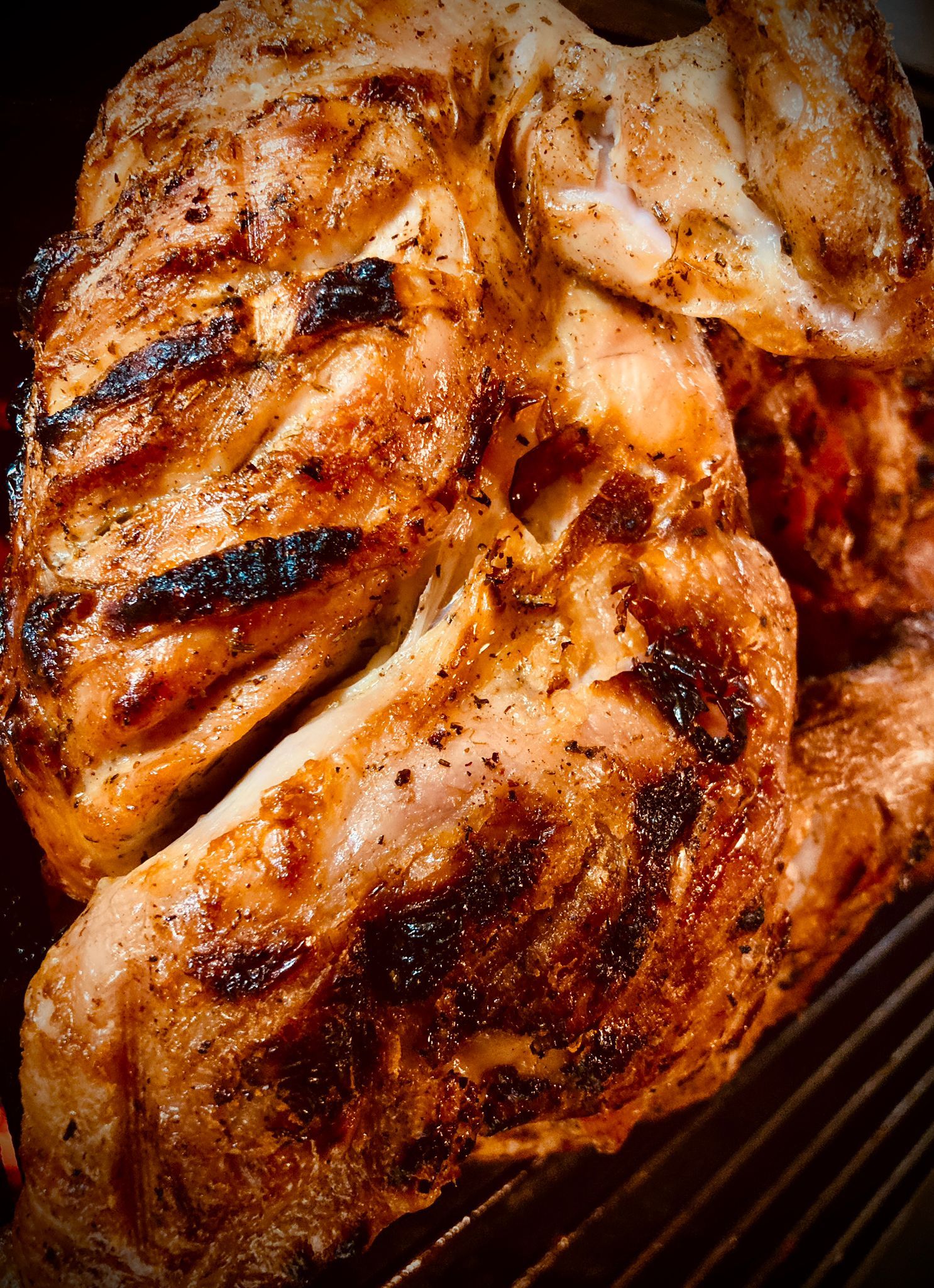 Pollo intero grigliato con i segni della griglia. Dorato, primo piano.