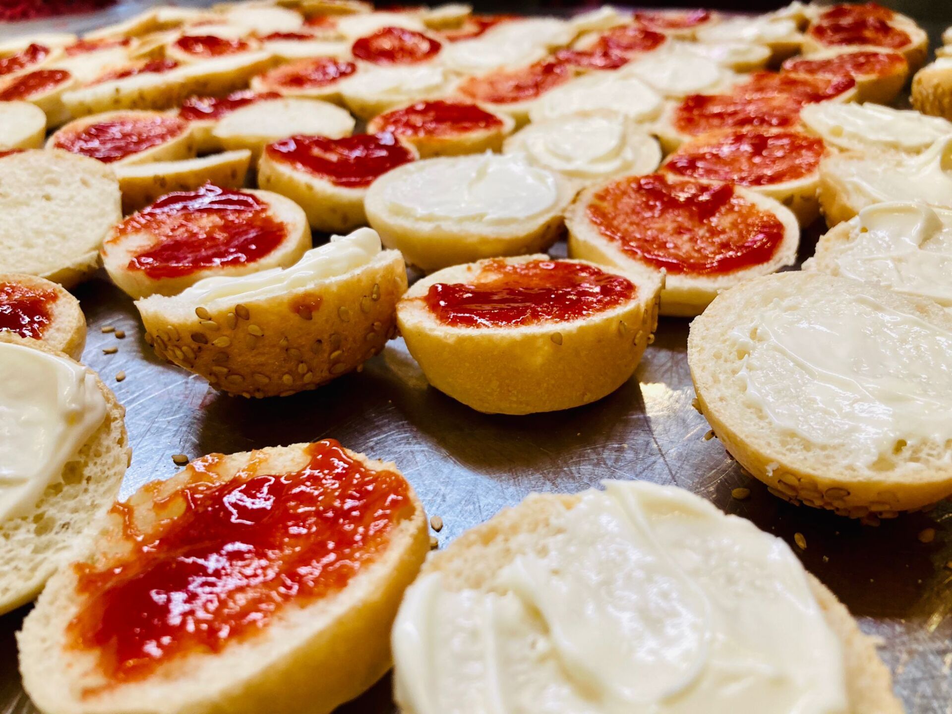 Panini con burro e marmellata, disposti su una superficie metallica.