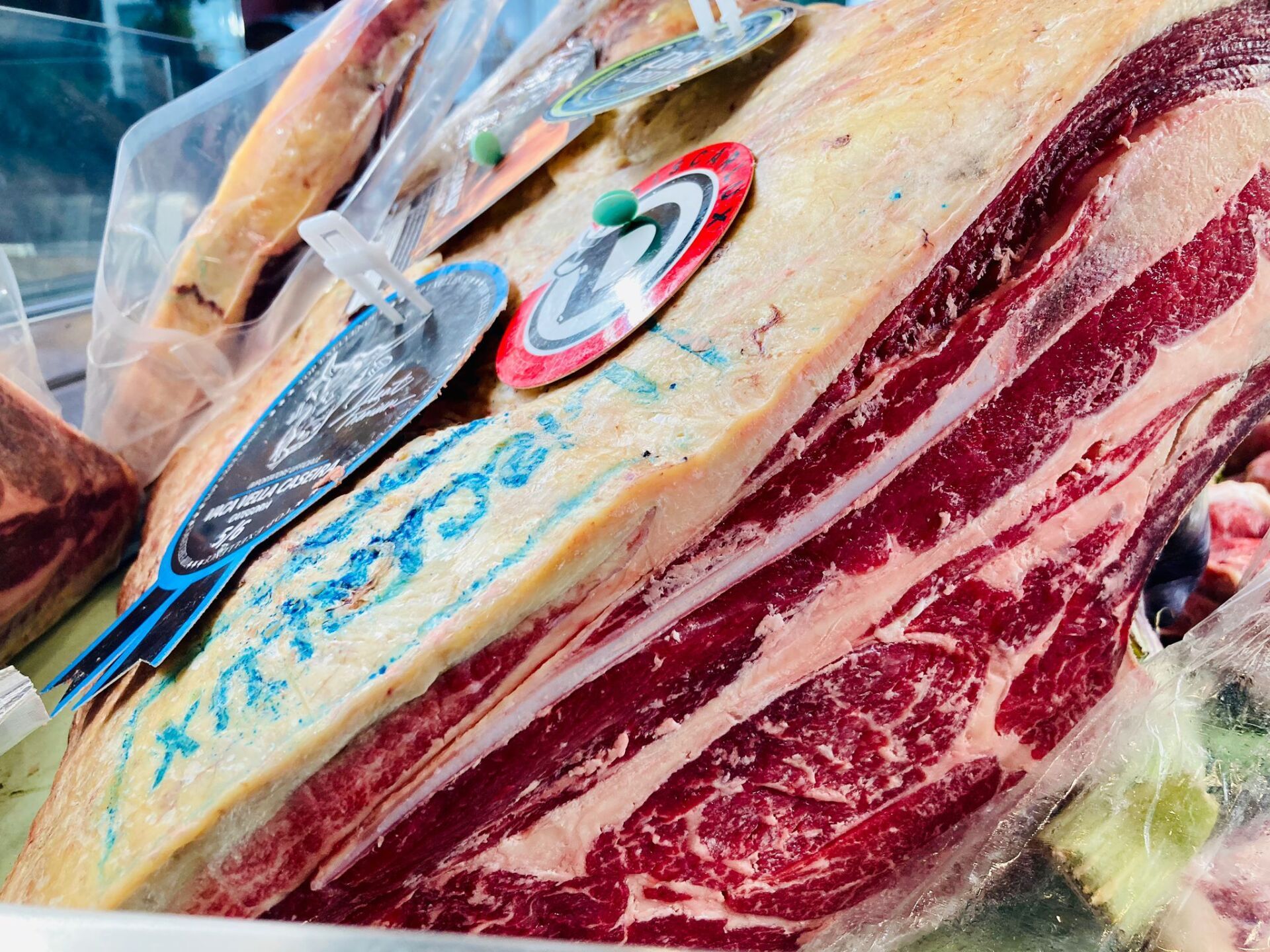 Primo piano di un grande taglio di carne cruda con un motivo rosso e bianco e le etichette attaccate.