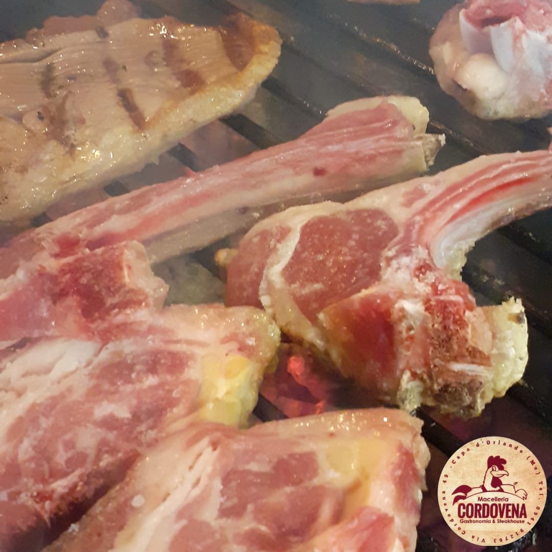 Costolette di agnello cotte alla griglia su un barbecue affumicato.