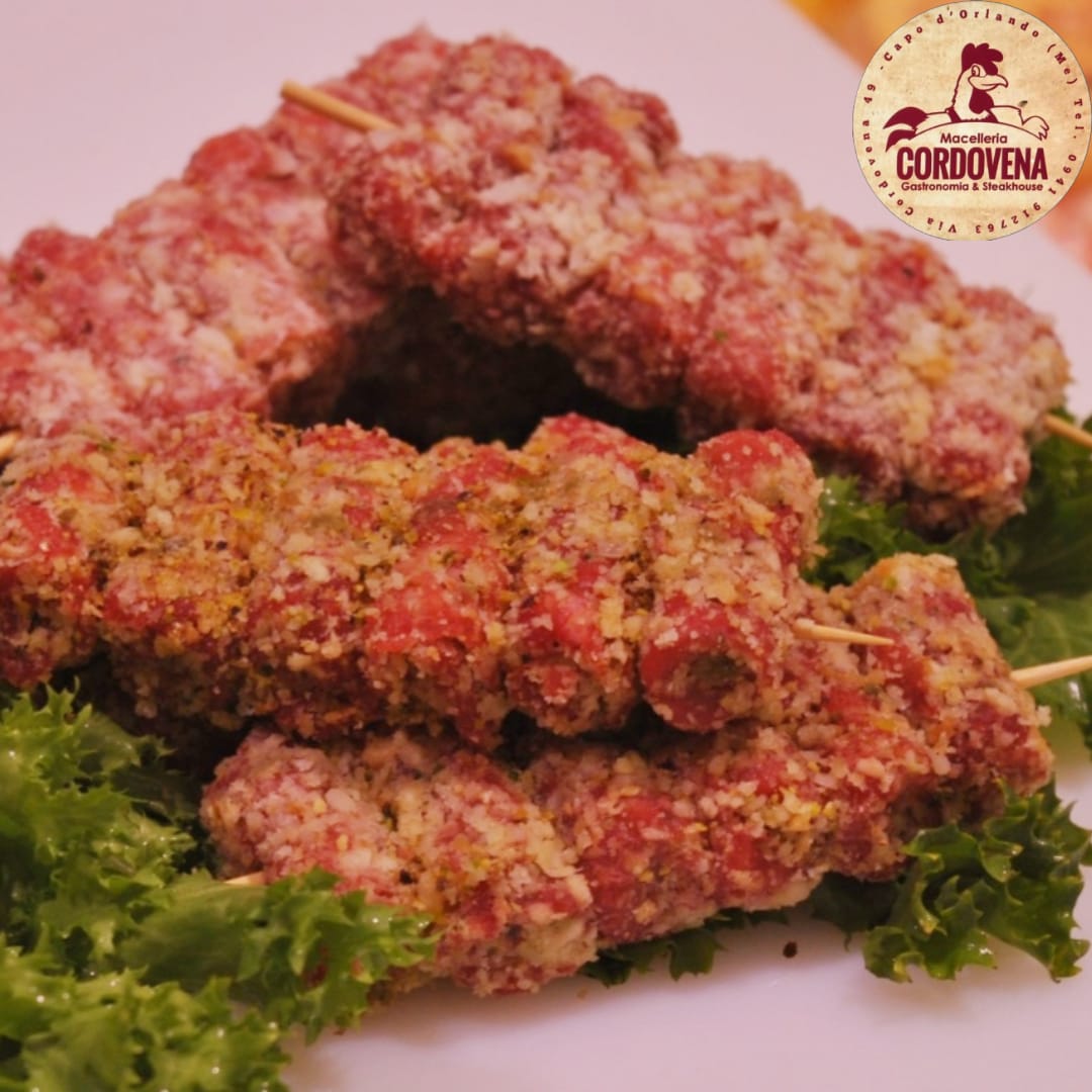 Antipasti di carne infilzata con panatura impanata, disposti su lattuga.