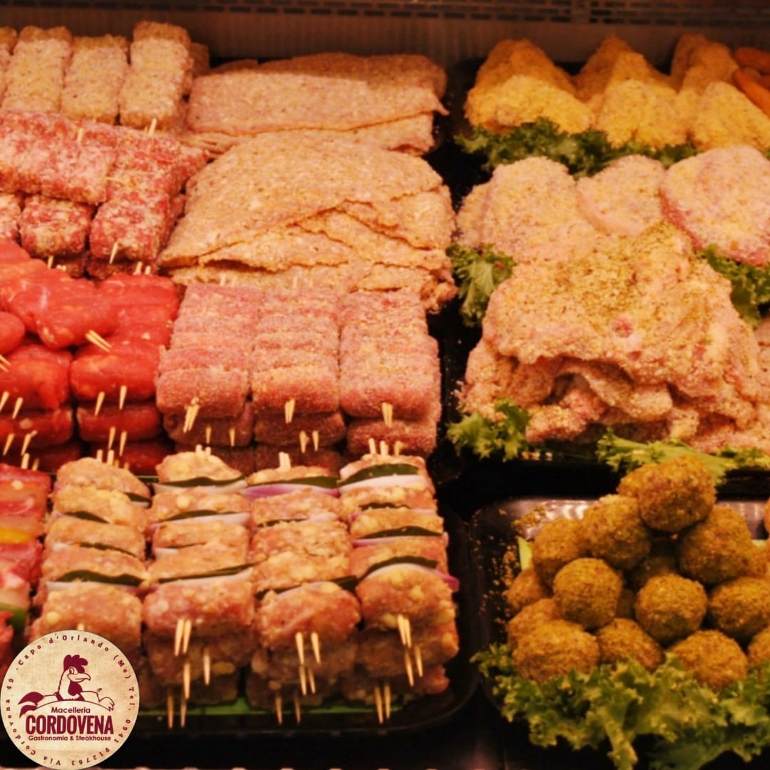 Vetrina con vari tipi di carne: spiedini, hamburger e polpette.