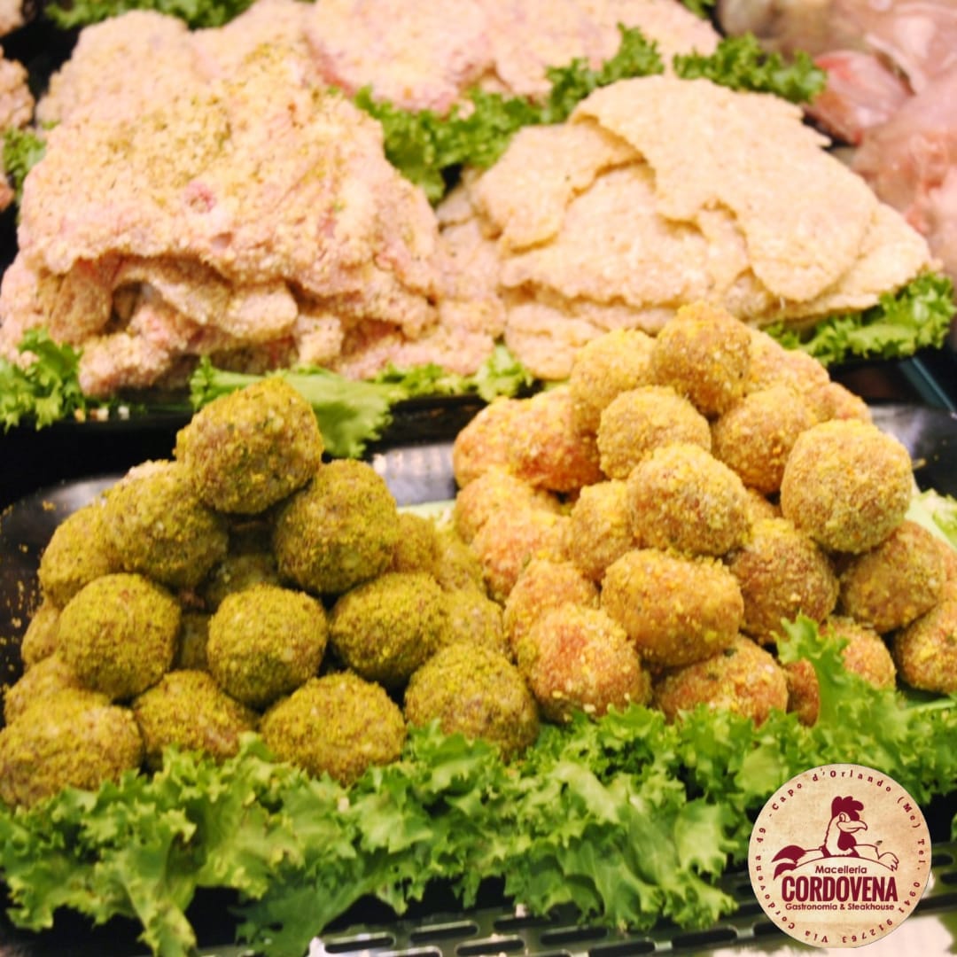 Prodotti di carne preparati in vetrina; cotolette e polpette in varie impanature.