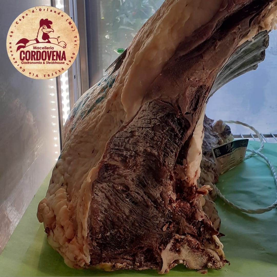 Grande taglio di carne cruda, probabilmente manzo, esposto in una vetrina. Contrassegnato con il logo Cordovena.