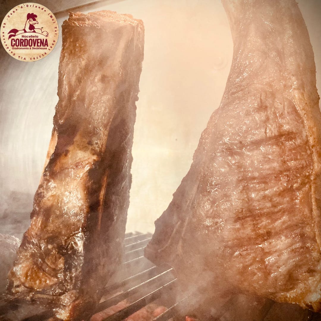 Due grandi tagli di carne vengono cotti alla griglia, emettendo vapore.