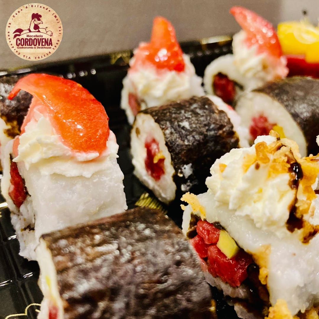 Rotoli di sushi con condimenti, primo piano, vassoio nero. Riso bianco, alga nori, tonno, gamberi, salse e guarnizioni.