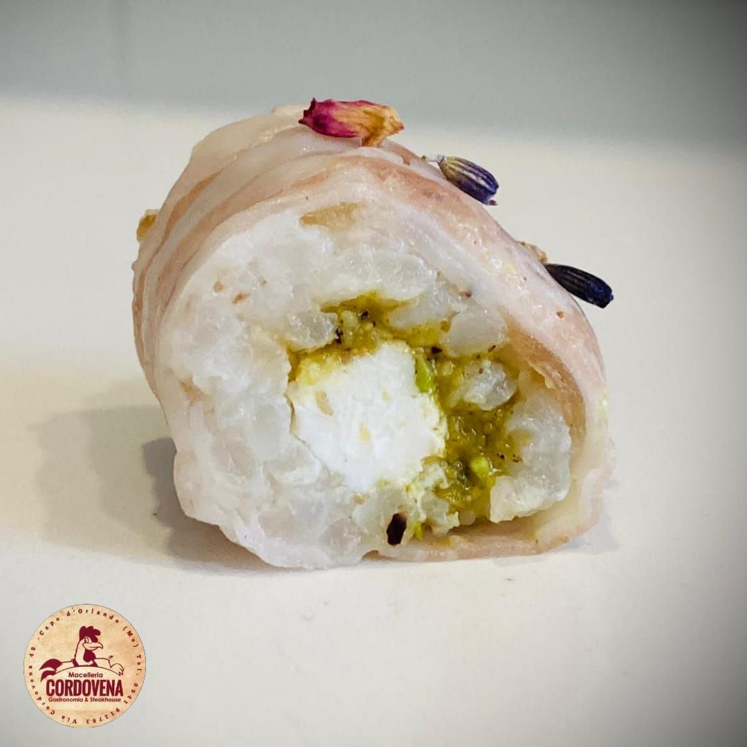 Rotolo di sushi con riso bianco, ripieno verde e guarnito con fiori secchi.