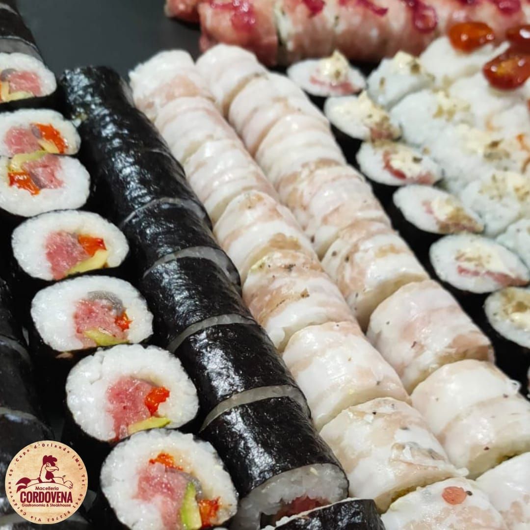 Involtini di sushi disposti su un vassoio, con vari ripieni e guarnizioni; primo piano.
