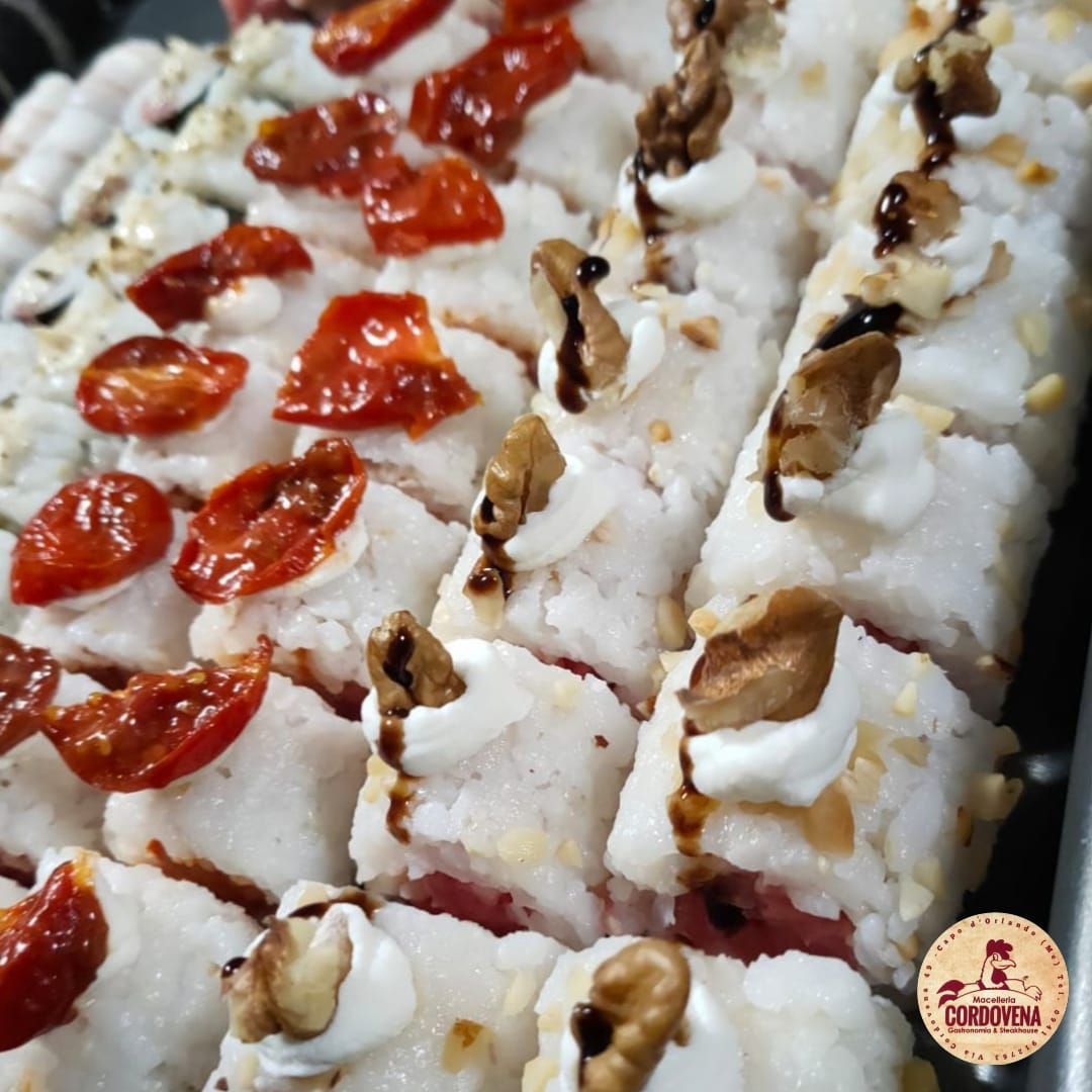 Involtini di sushi conditi con pomodori e noci, conditi con salsa.