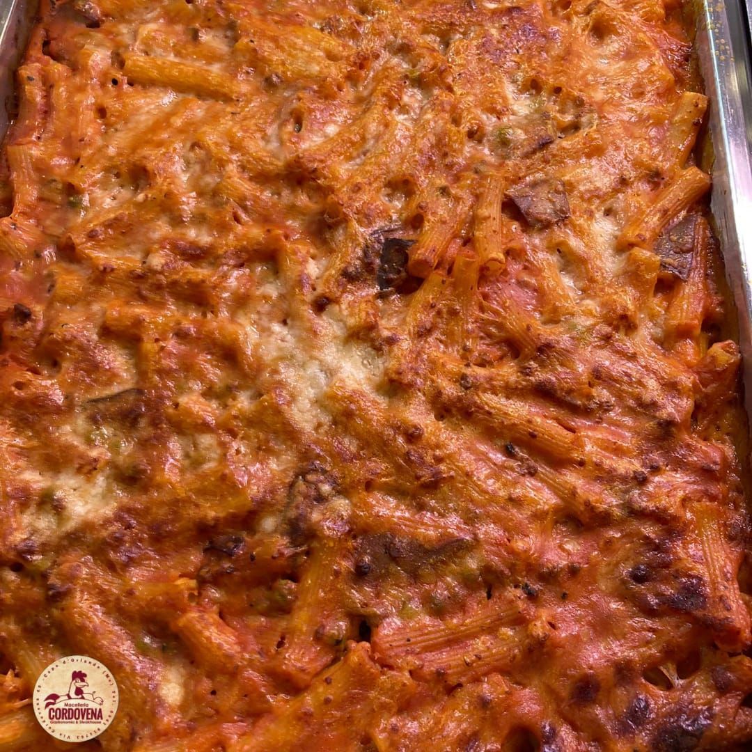 Piatto di pasta al forno in una teglia rettangolare; salsa all'arancia, formaggio e pasta visibili.