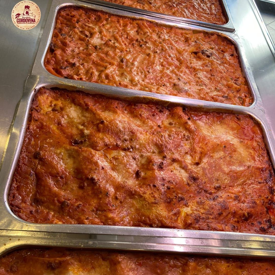 Diversi vassoi rettangolari pieni di pirofile cotte al forno.