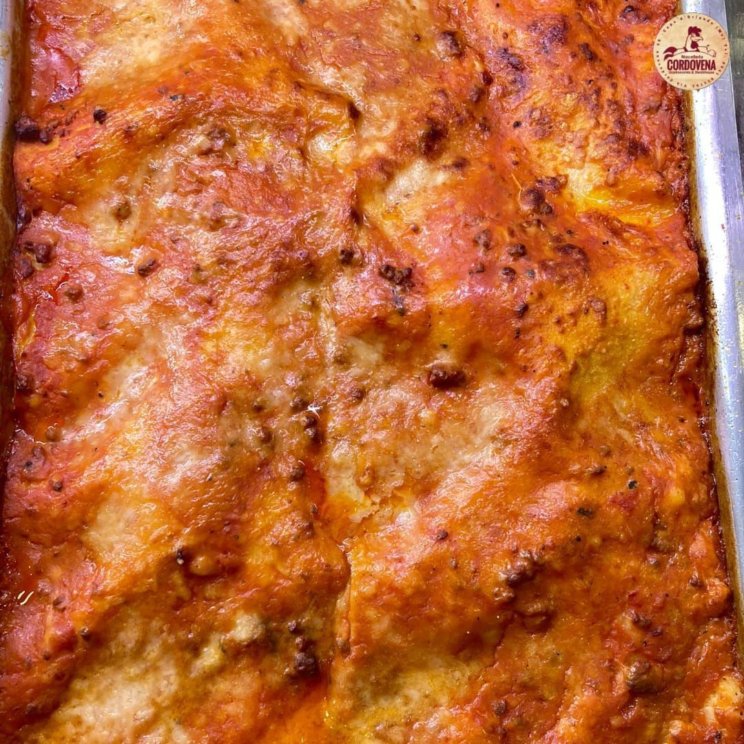 Lasagna cotta al forno in una teglia di metallo, con strati di salsa, formaggio e pasta.
