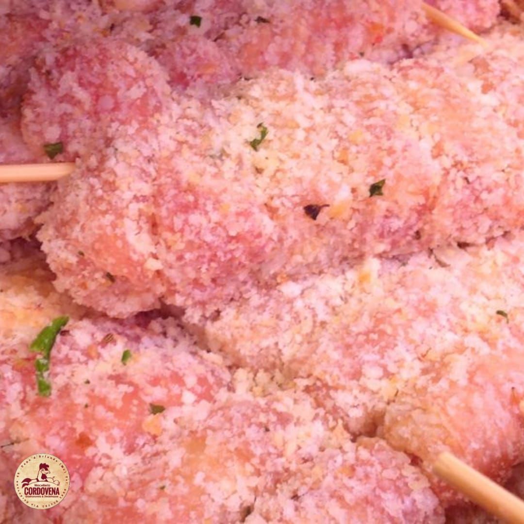 Carne impanata e infilzata, primo piano.