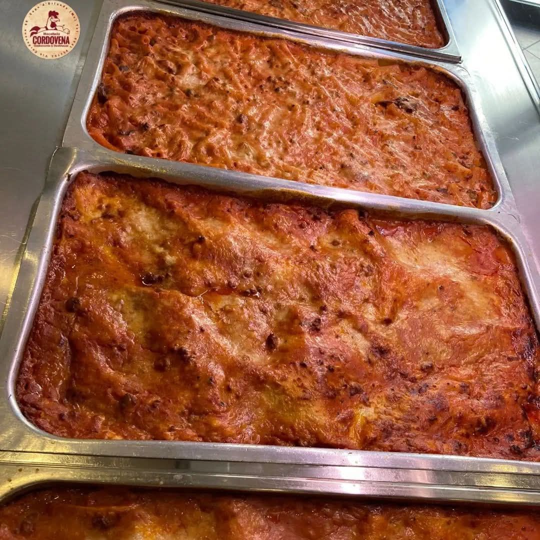 Teglia di lasagna al forno con superficie dorata e ruvida.