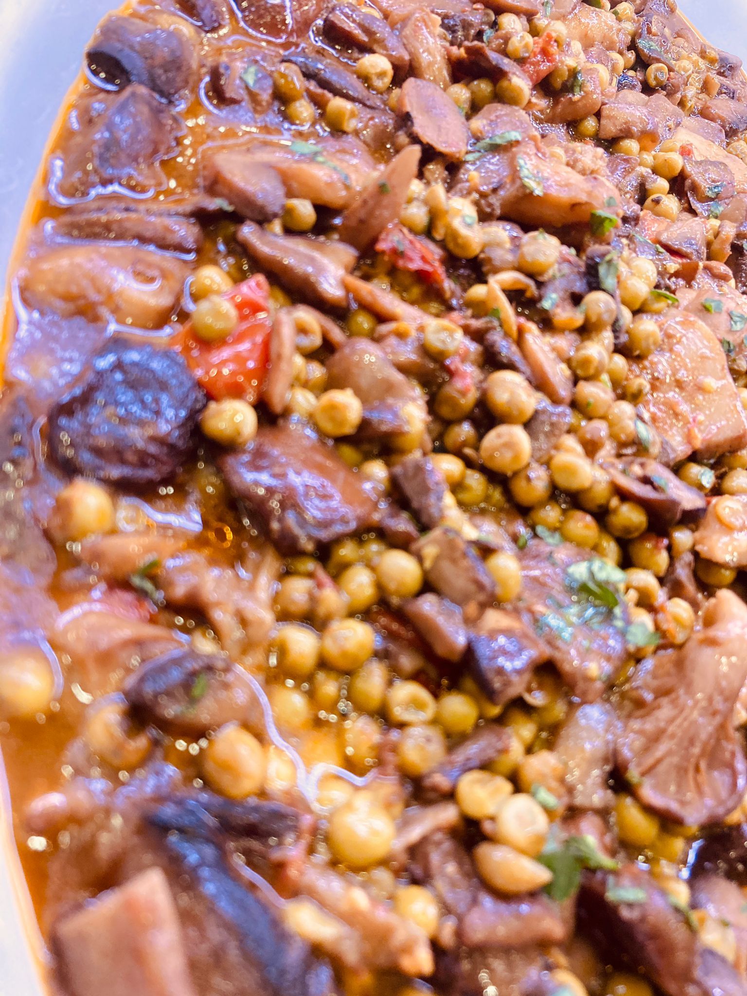 Stufato con funghi, piselli e pomodori in salsa bruna.