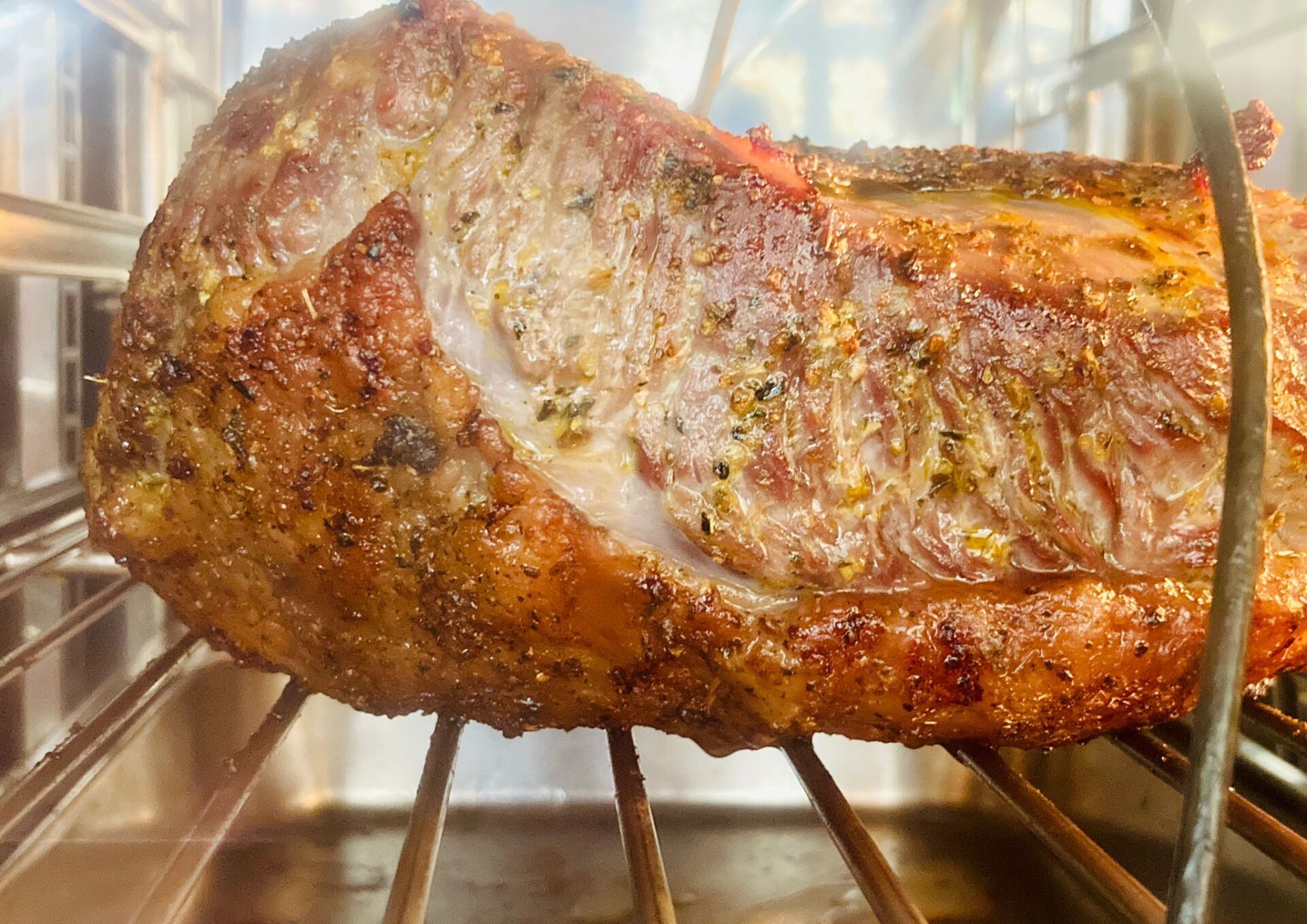 Arrosto di maiale su una griglia di metallo all'interno di un forno.