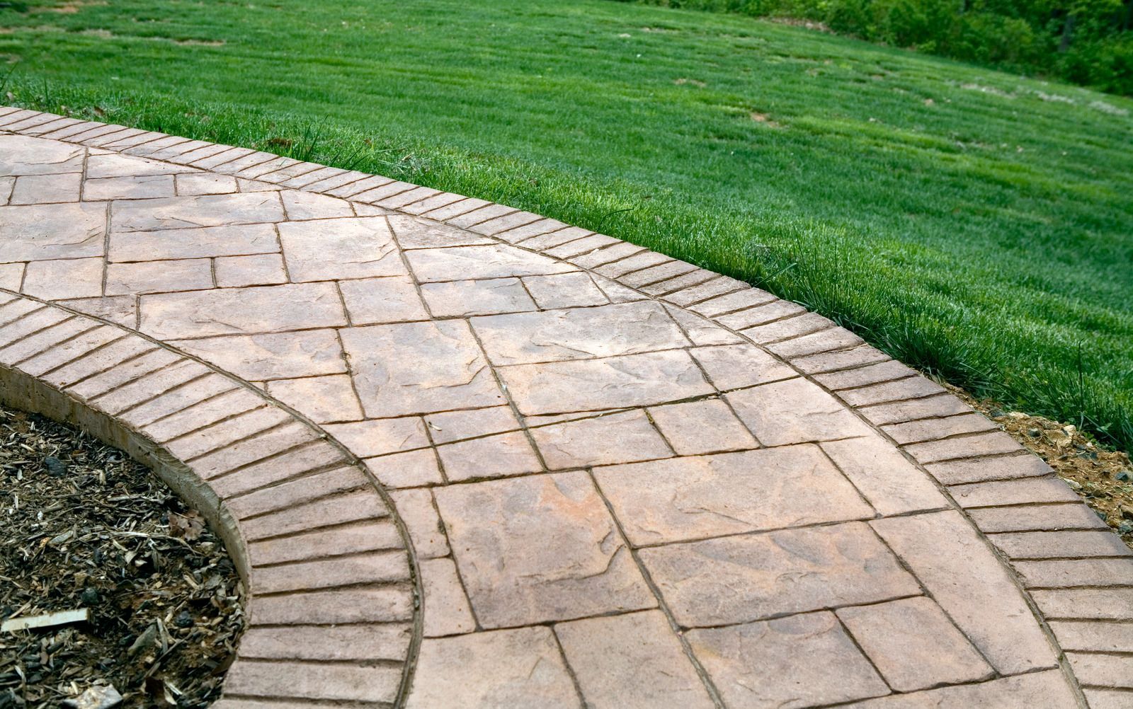 Stone walkway curves through green grass.