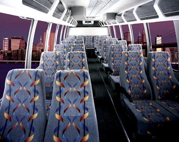 The inside of an empty bus with a city in the background