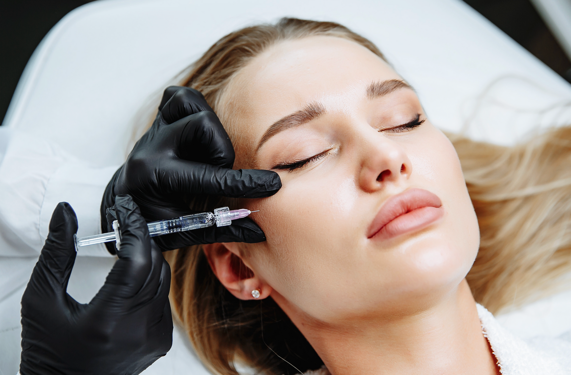 A woman is getting a botox injection in her face.
