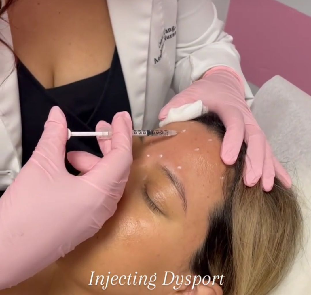 A woman is getting an injection in her forehead by a doctor wearing pink gloves