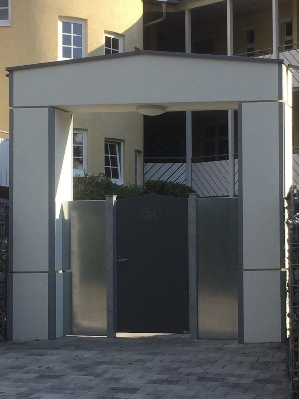 Ein weißes Gebäude mit einem schwarzen Tor davor