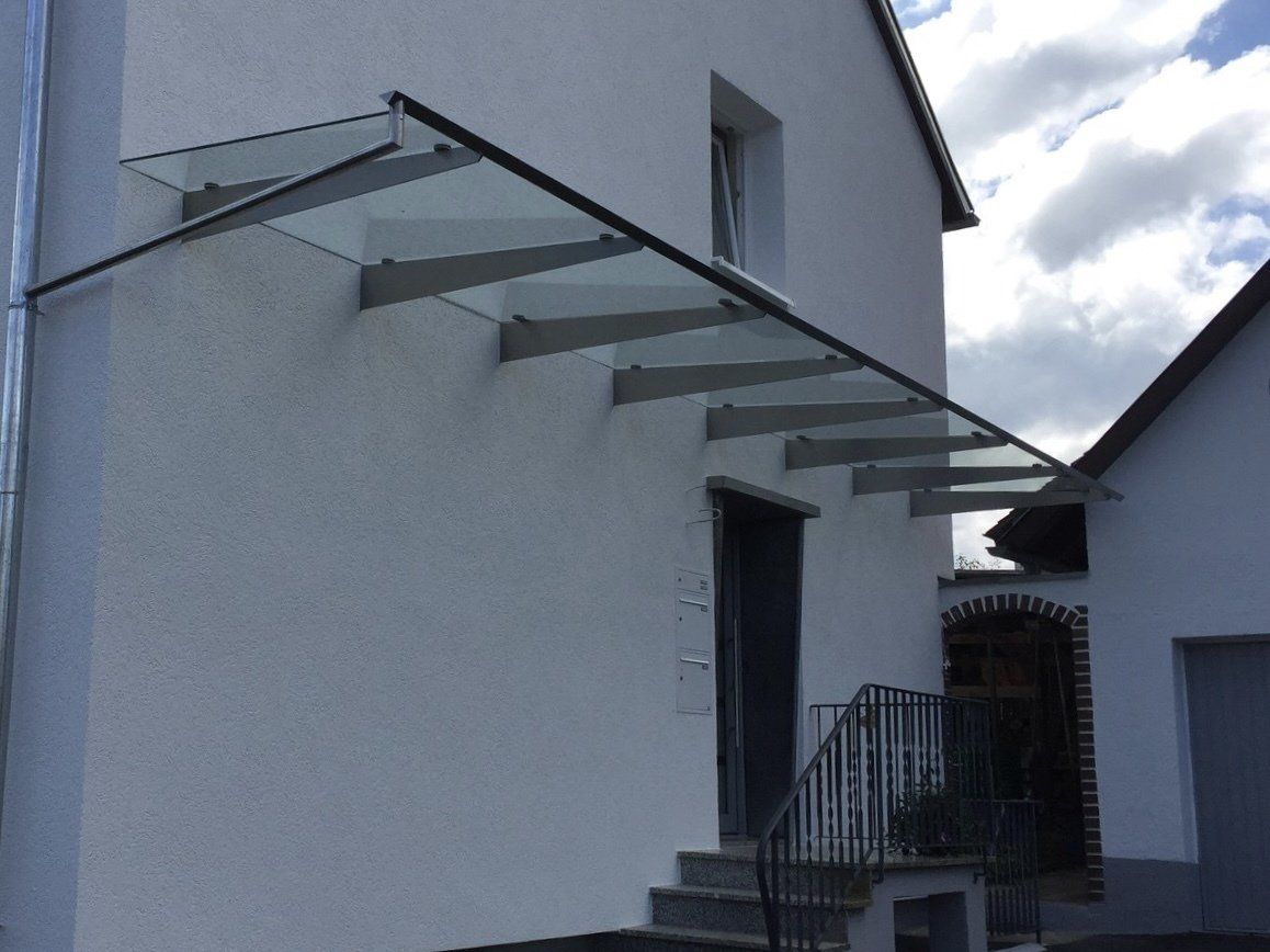Ein weißes Gebäude mit einem Glasdach über der Eingangstür