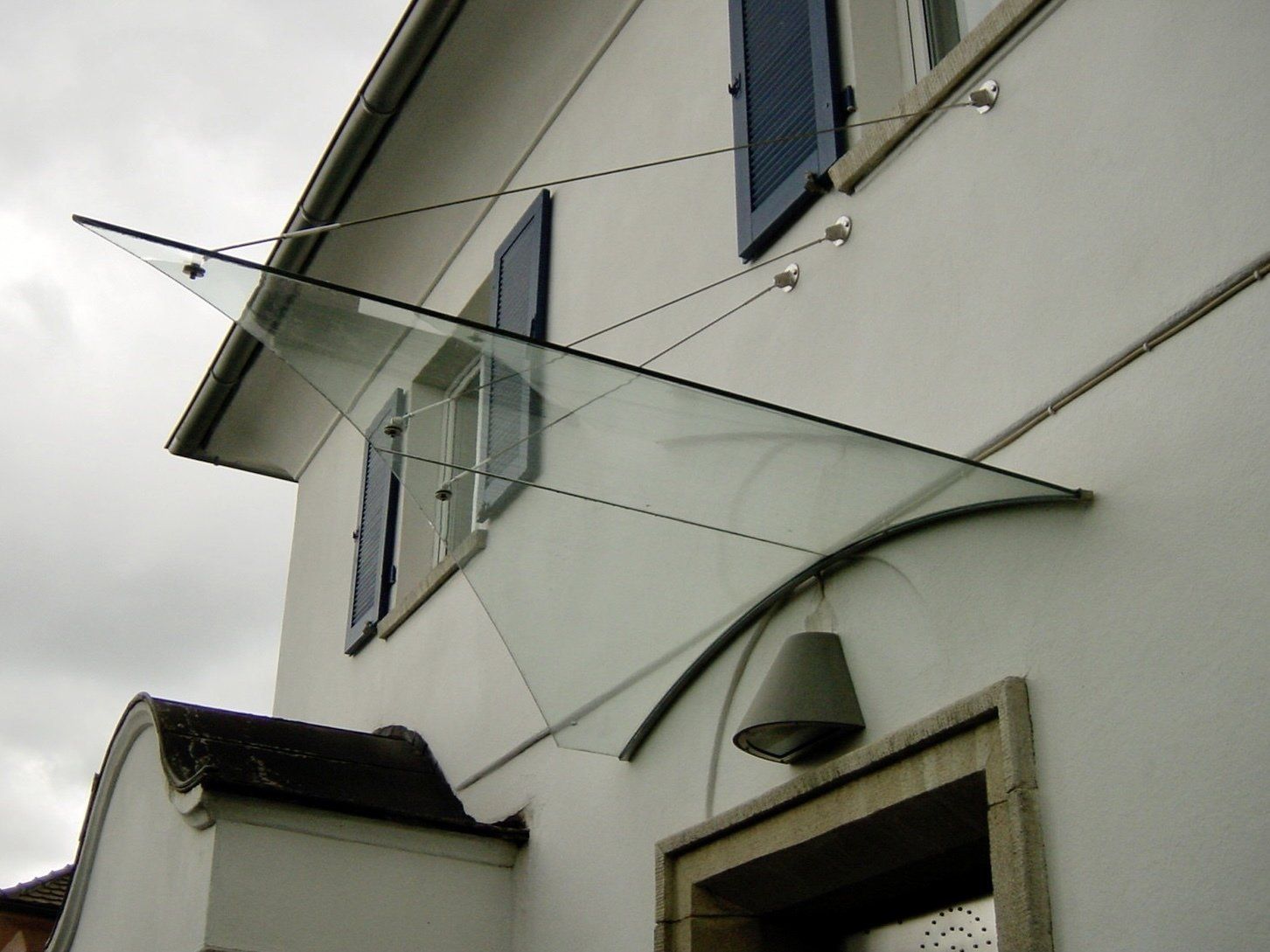 Ein weißes Gebäude mit einem Glasdach über der Tür