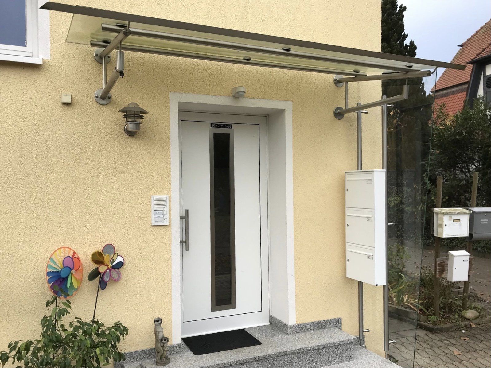 Ein gelbes Haus mit einer weißen Tür und einem Briefkasten