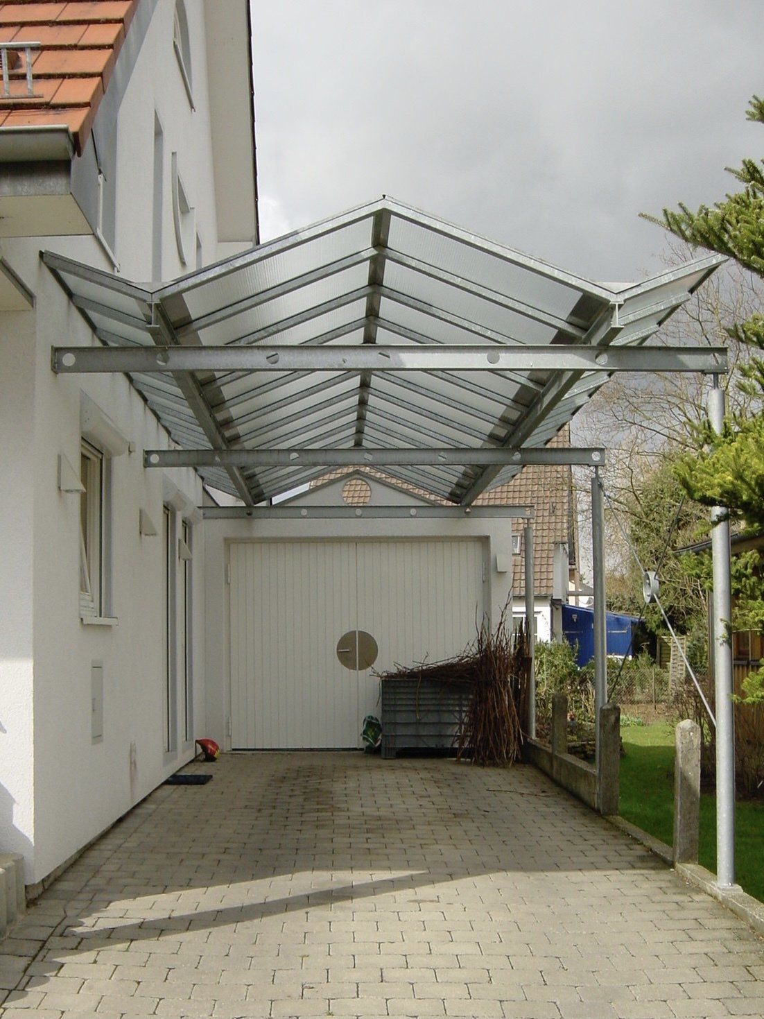 Eine Auffahrt, die zu einer Garage mit Glasdach führt