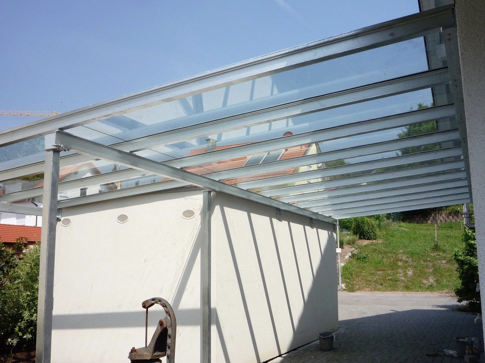 Ein Carport mit Glasdach und Metallrahmen