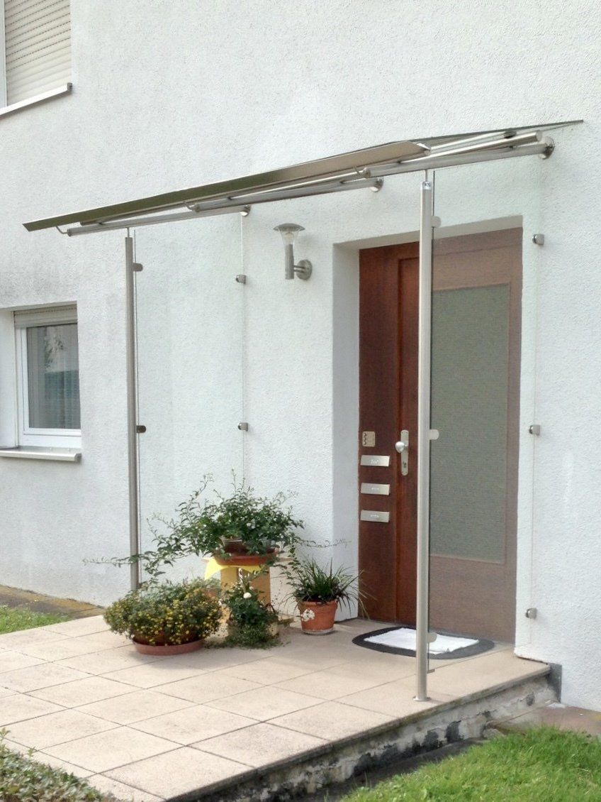 Ein weißes Haus mit einem Glasdach über der Eingangstür