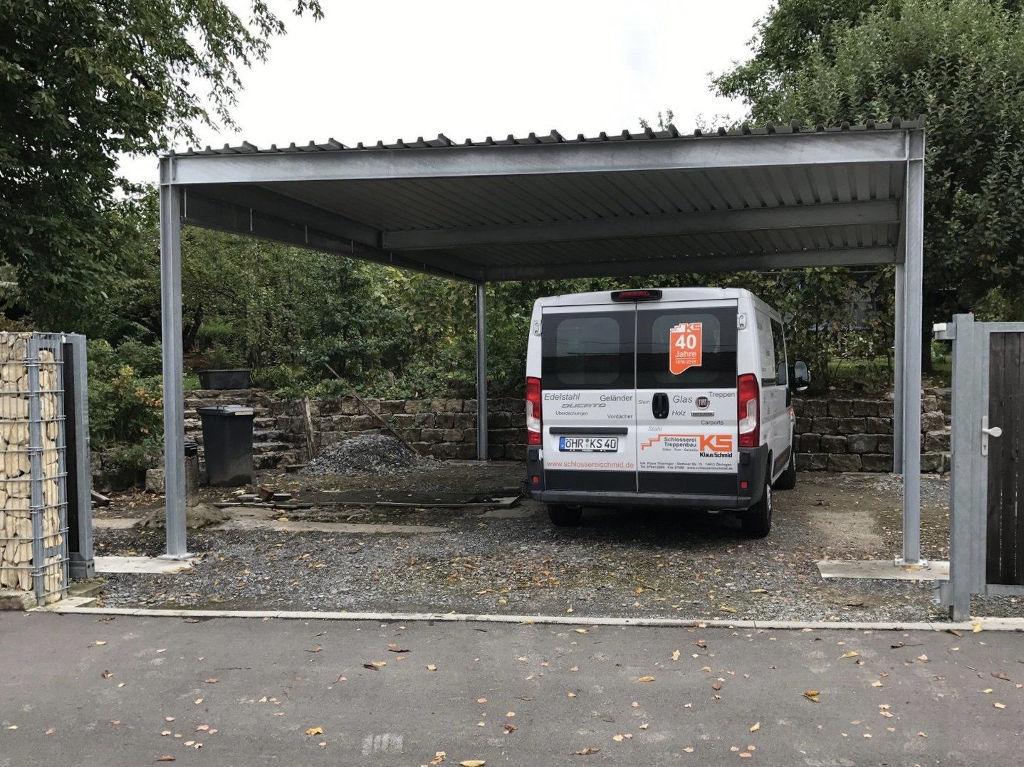 Ein weißer Lieferwagen steht unter einem Carport