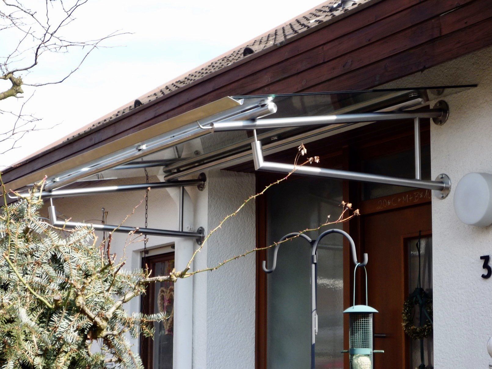Ein Vogelhäuschen hängt vom Dach eines Hauses