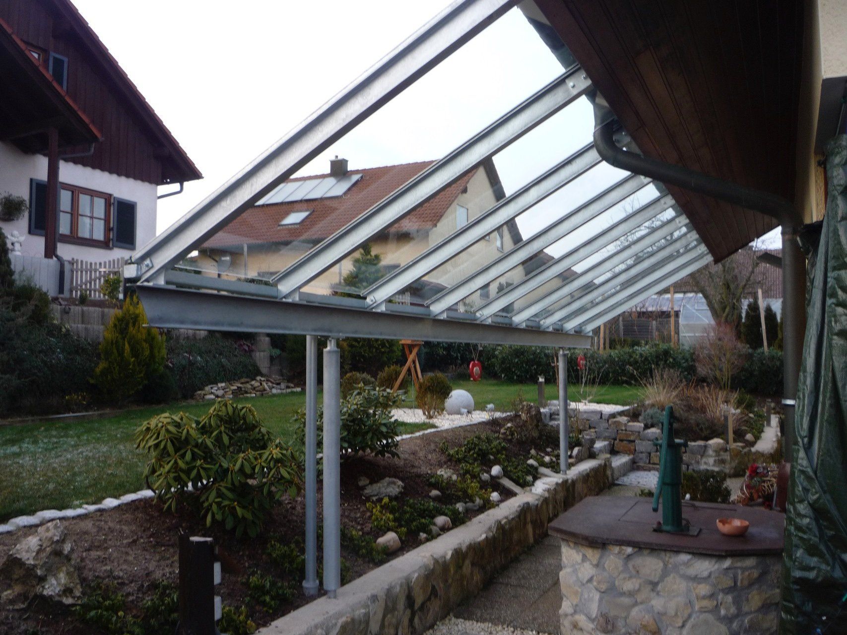 Ein Haus mit einem Glasdach und einer Steinmauer