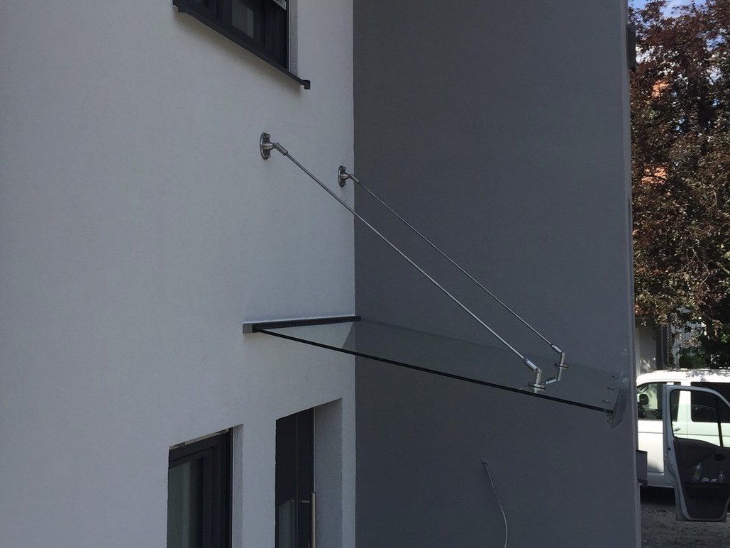 Ein weißes Gebäude mit einem Glasdach an der Seite.