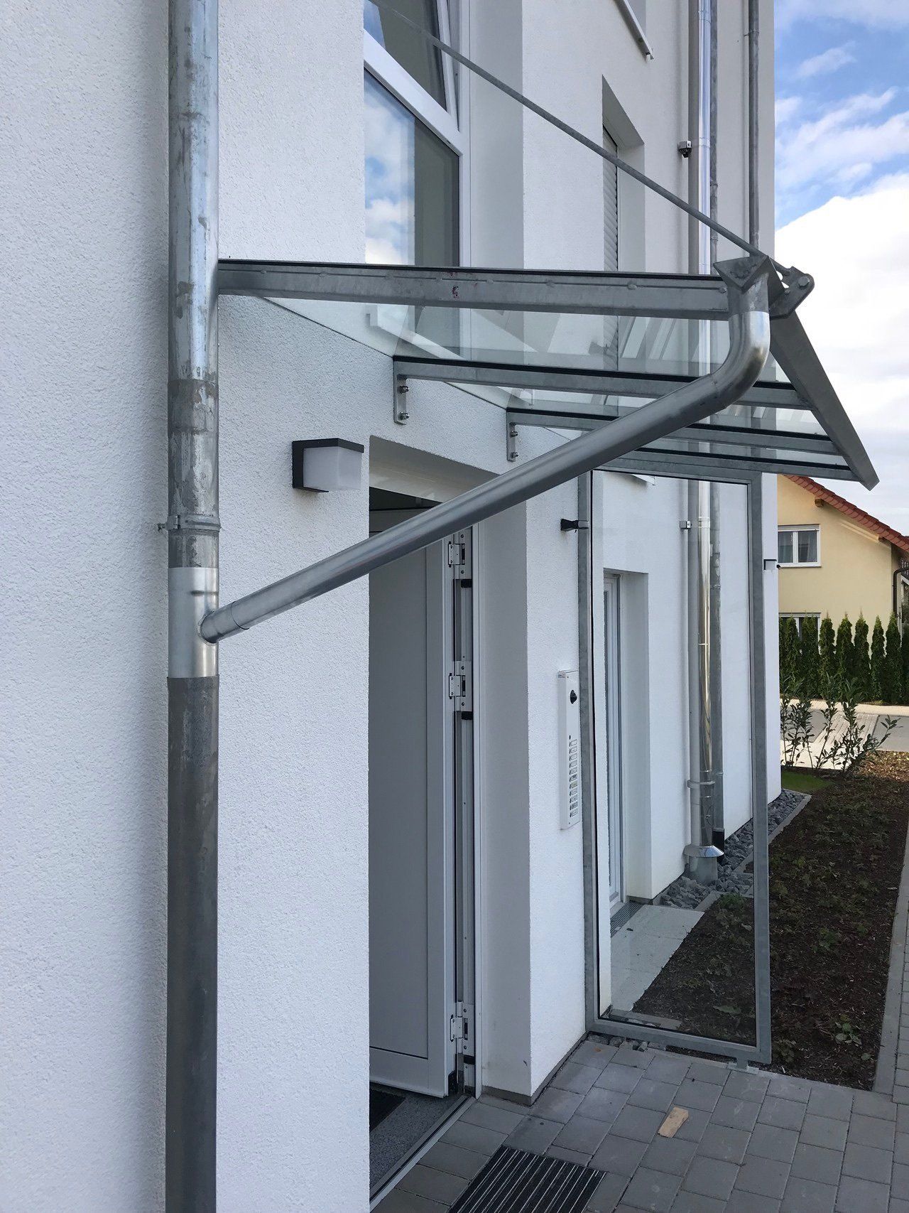 Ein weißes Gebäude mit einem Glasdach über der Tür