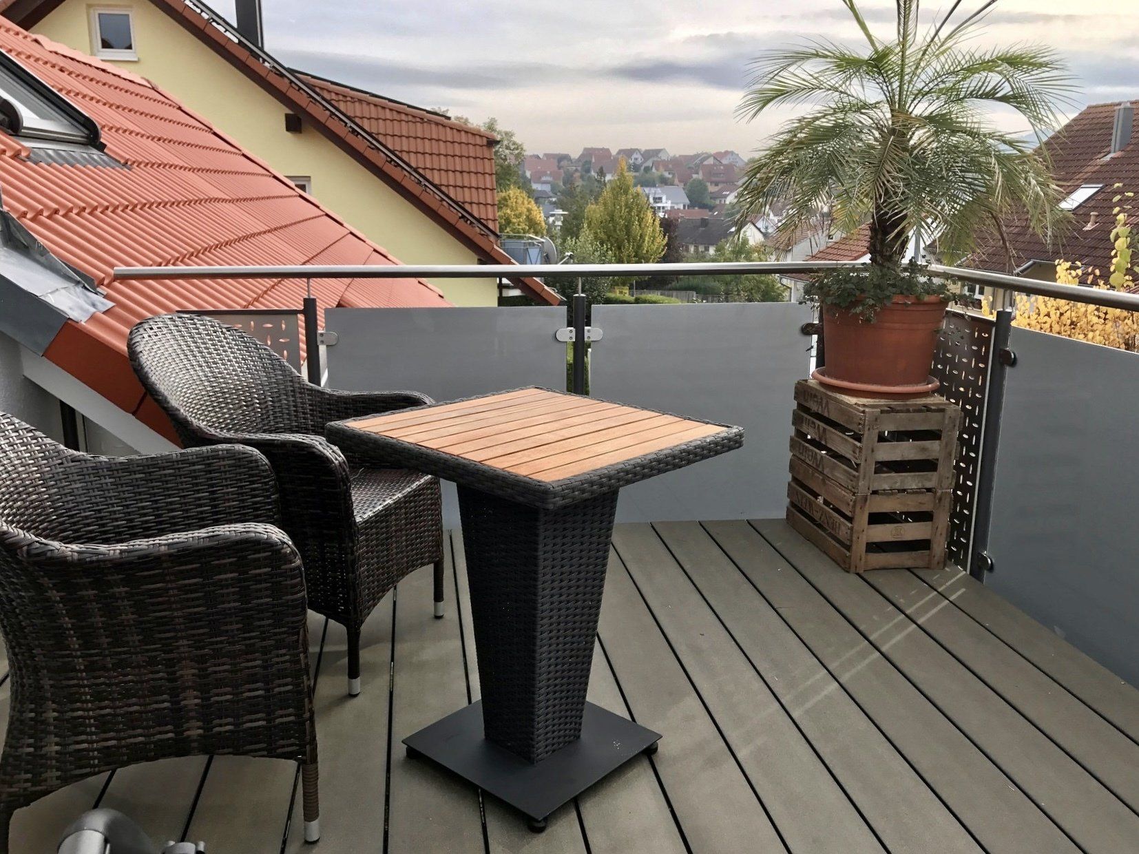 Ein Balkon mit Korbstühlen und einem Tisch