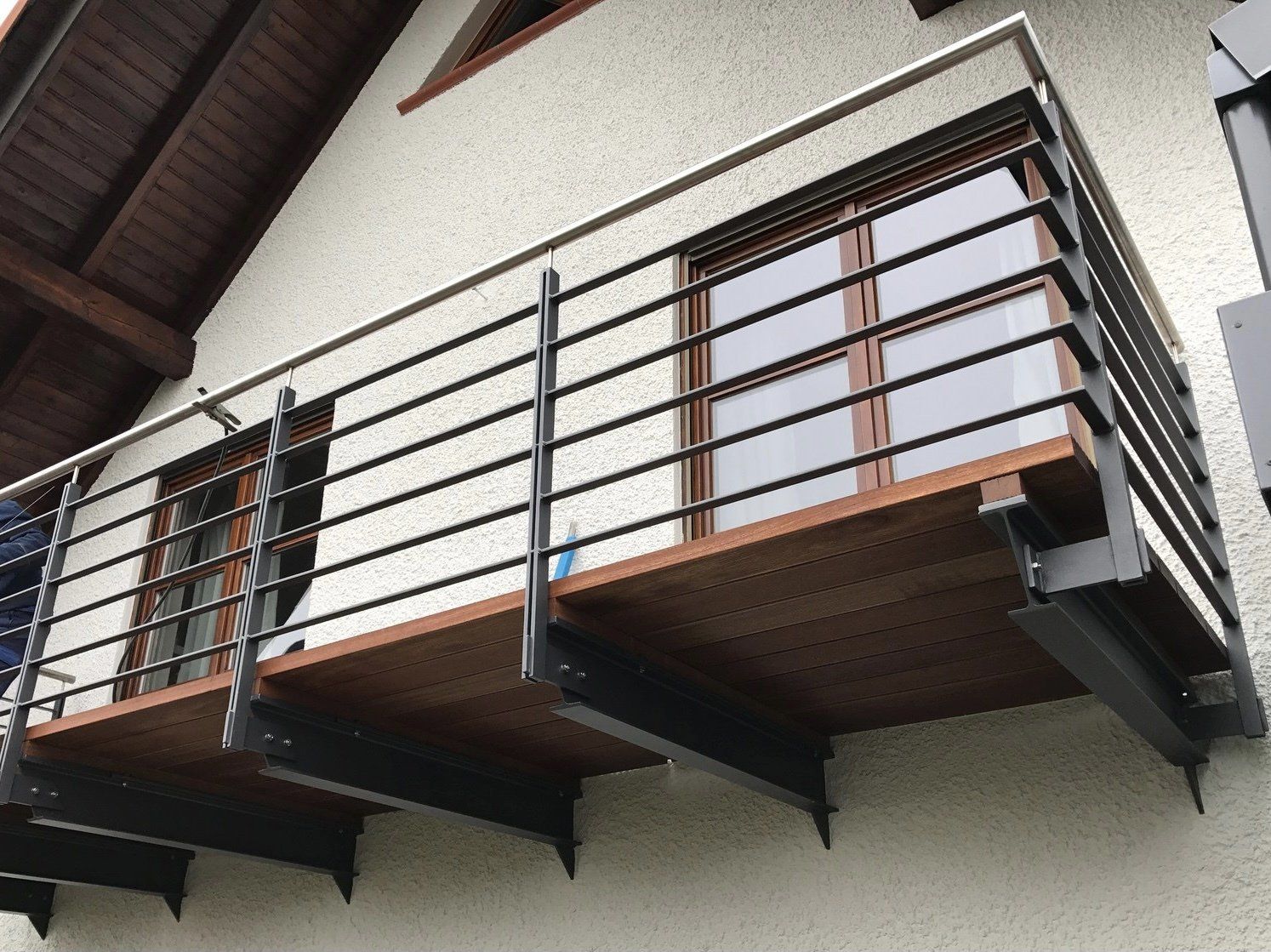 Ein Balkon an der Seite eines Gebäudes mit einem Metallgeländer