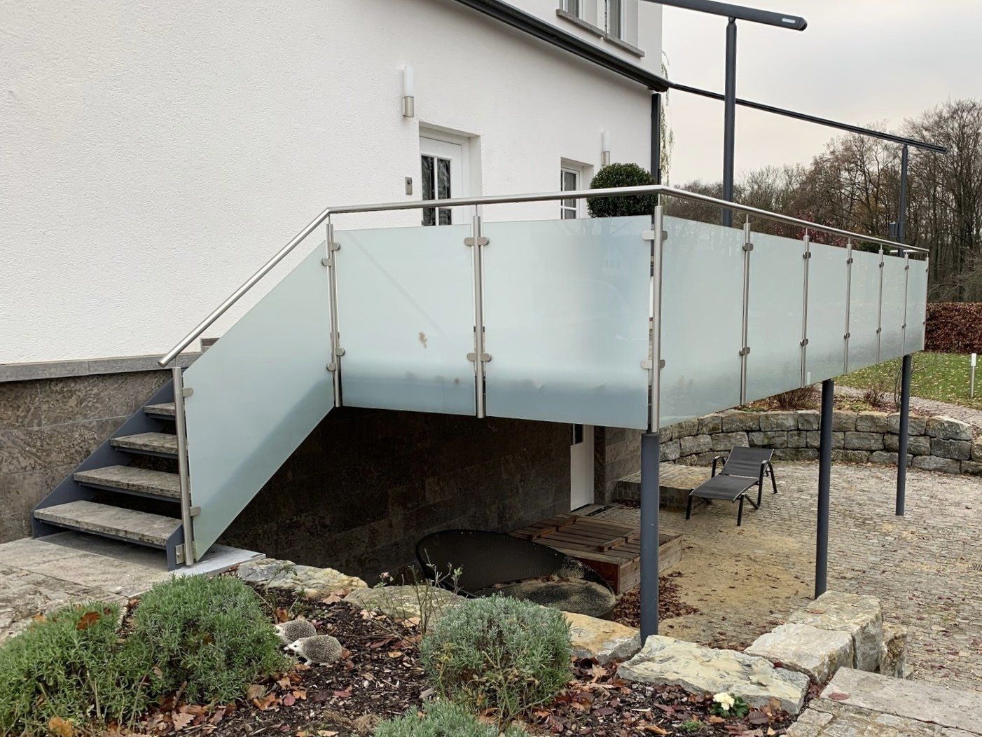 Ein weißes Haus mit einem Balkon und einer Treppe, die dorthin führt