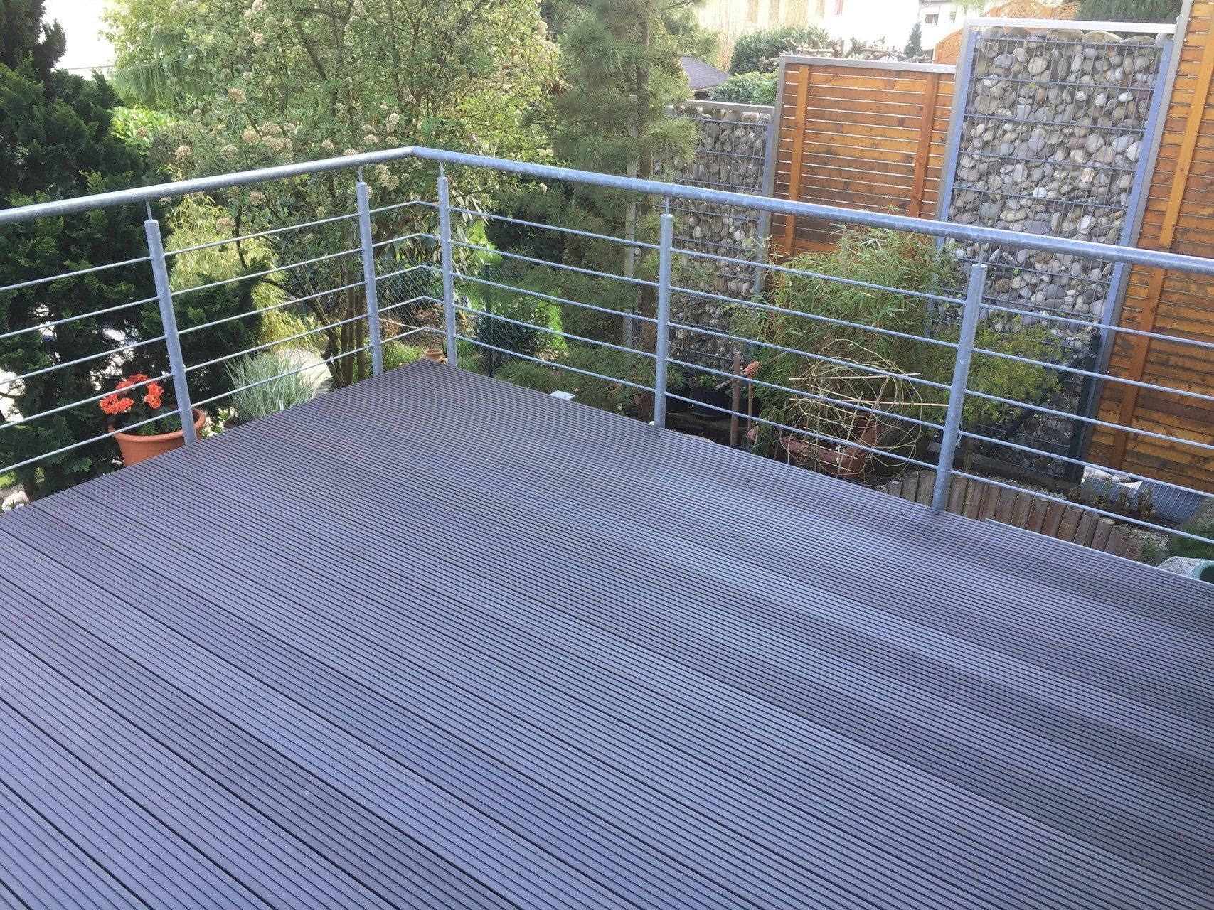 Ein Balkon mit Metallgeländer und Holzdeck.