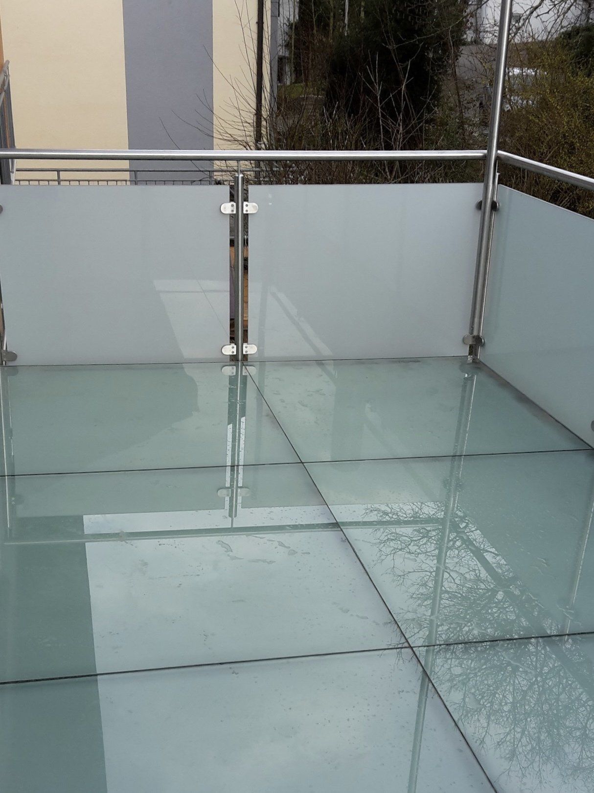 Ein Balkon mit Glasboden und Edelstahlgeländer.