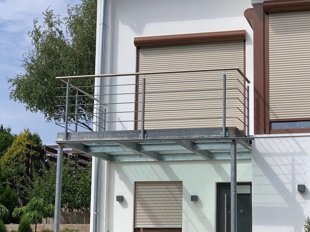 Ein weißes Haus mit Balkon und Fensterläden