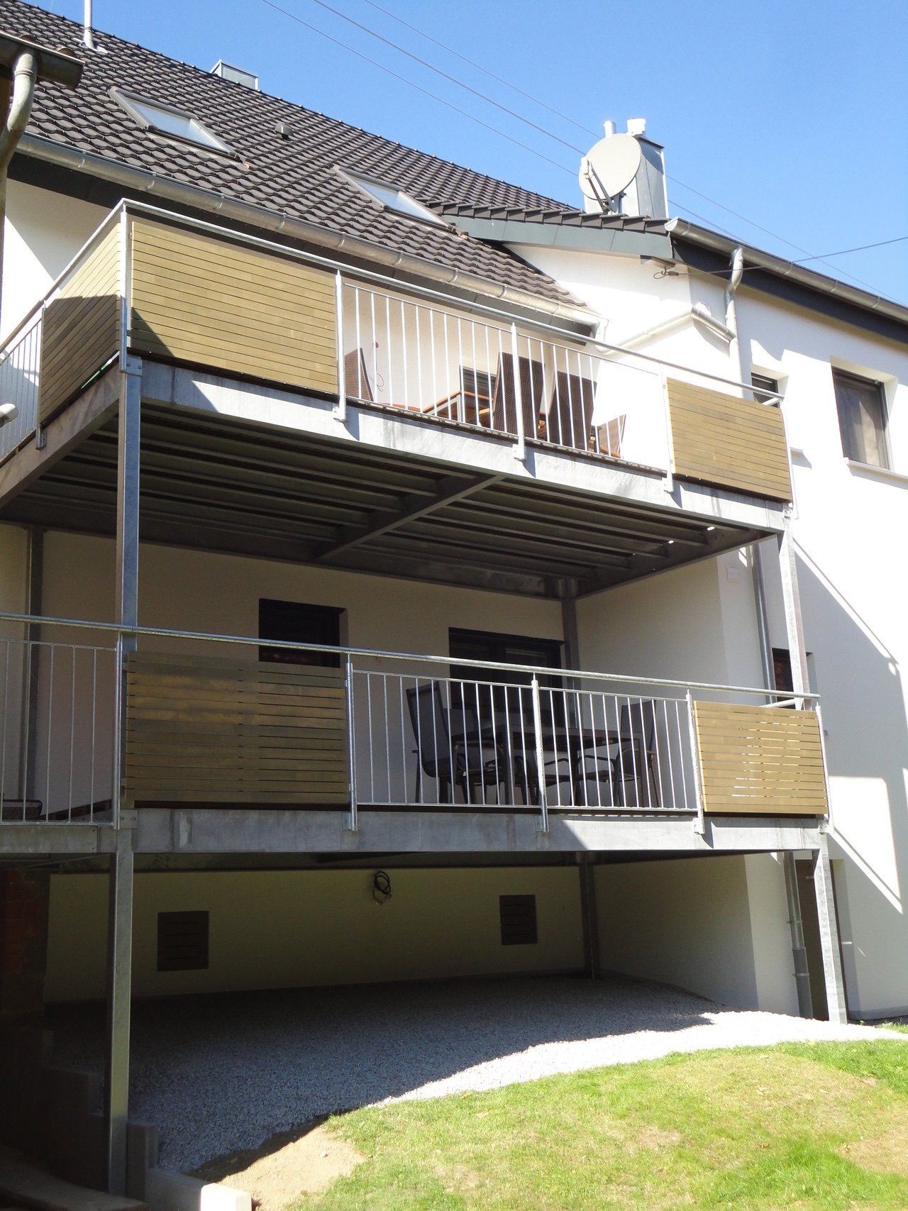 Ein weißes Haus mit Balkon und Satellitenschüssel auf dem Dach