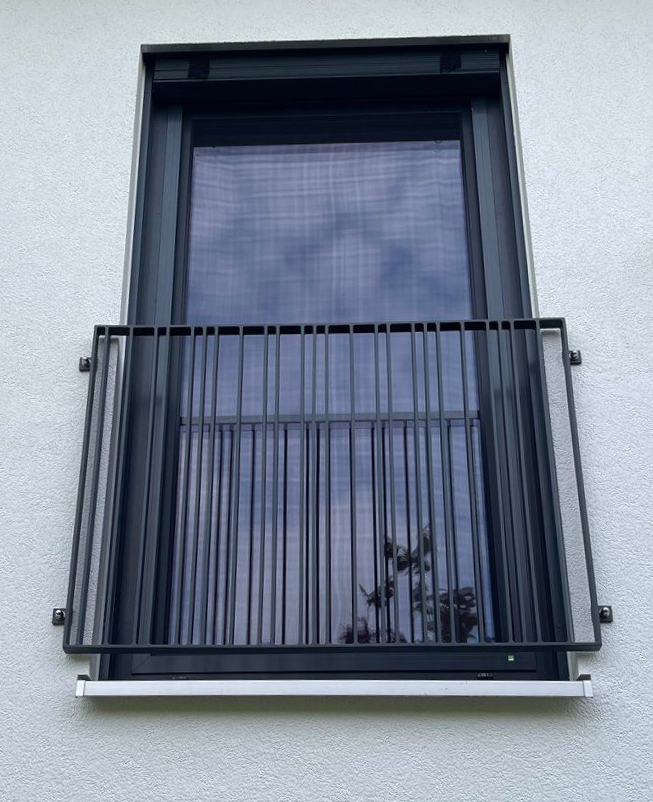 Ein Fenster mit einem schmiedeeisernen Zaun darum