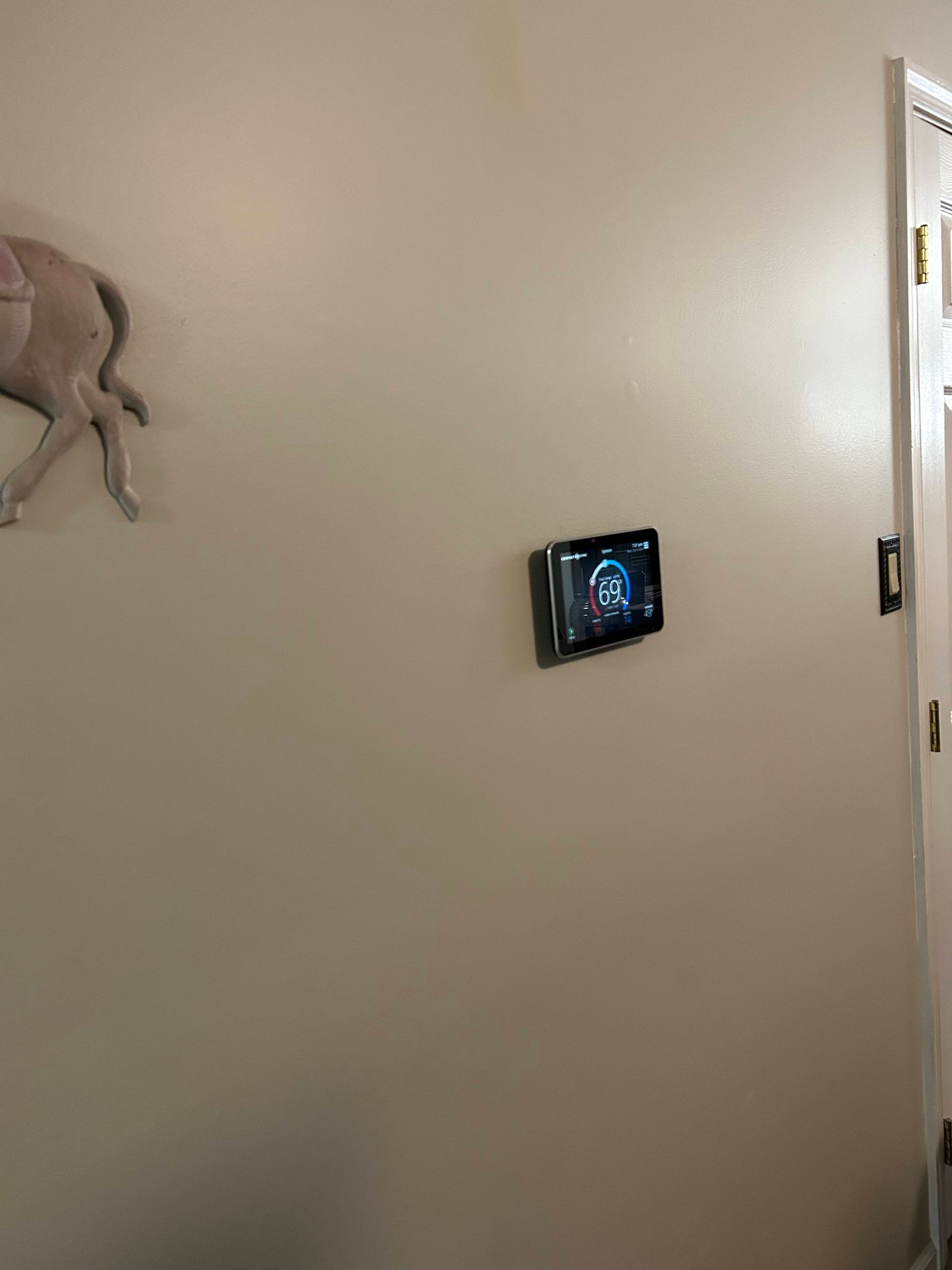 Hallway wall with a small mounted screen and a decorative octopus sculpture