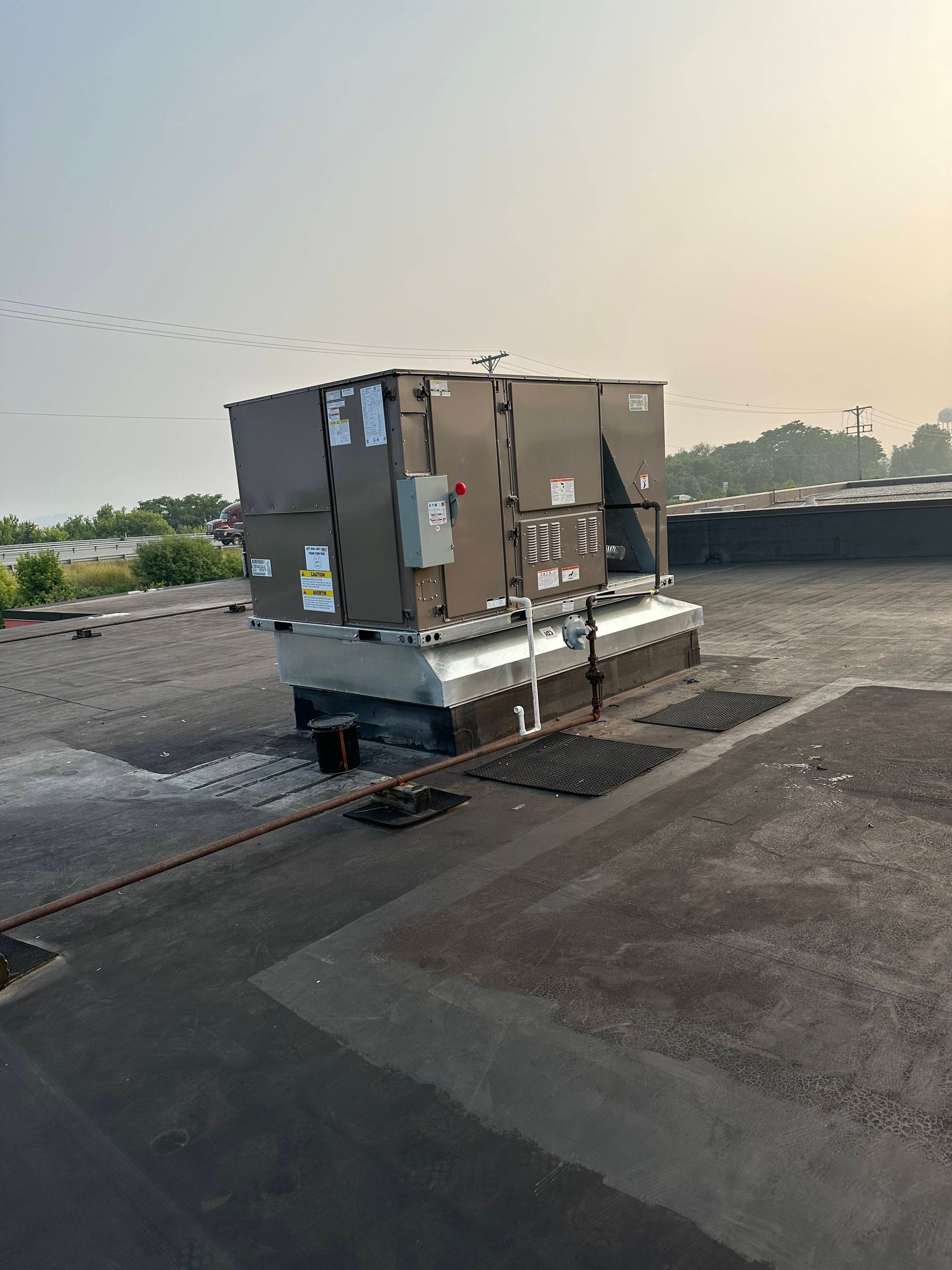 Large metal rooftop HVAC unit on a flat roof at dusk