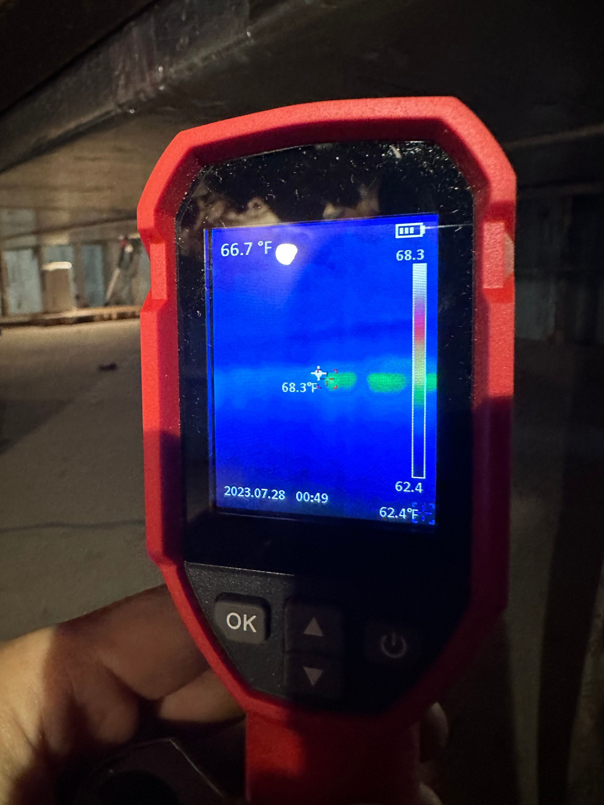 Thermal camera displaying temperature readings; blue and green areas indicate cooler spots.