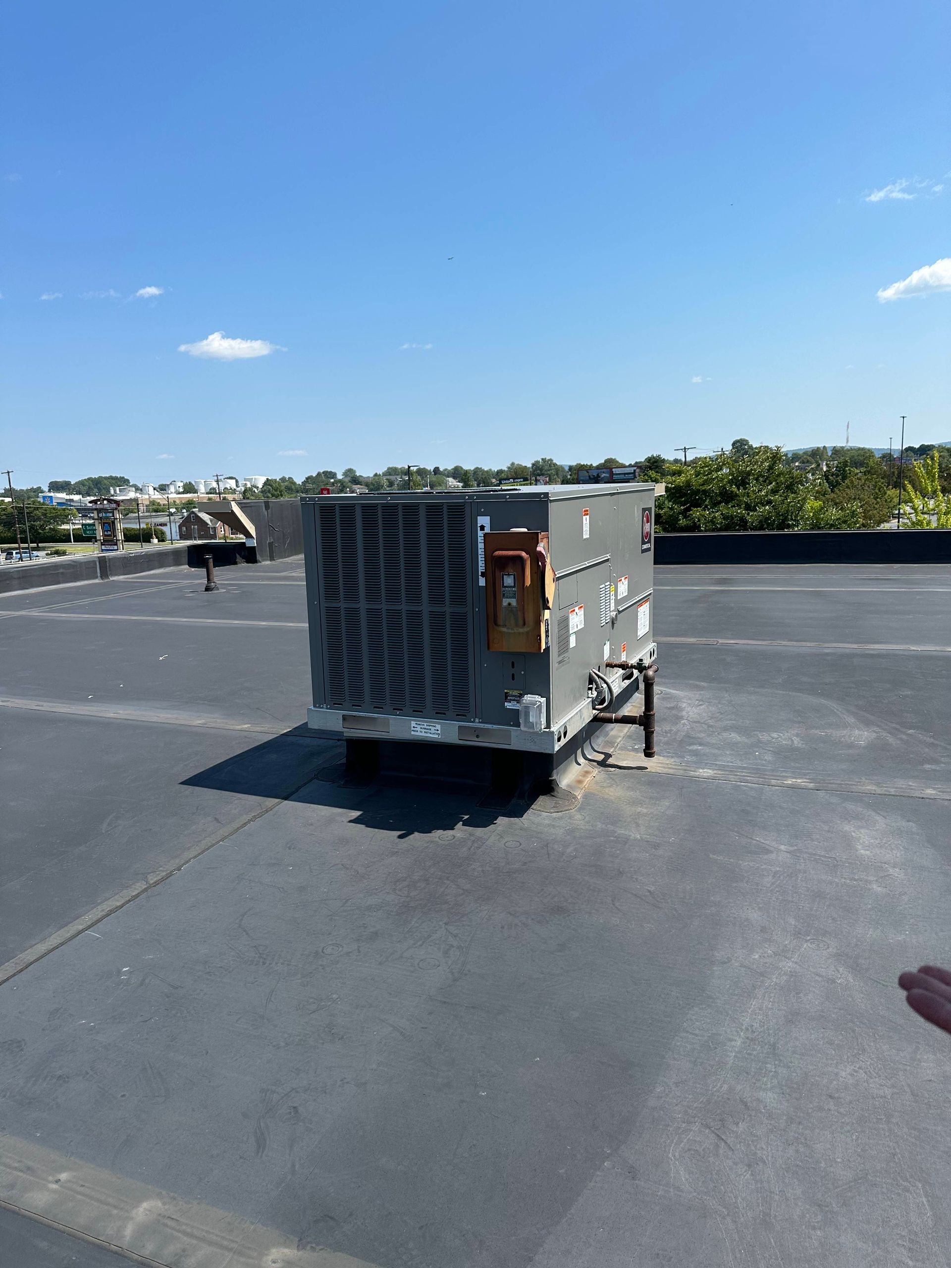 HVAC unit on a flat rooftop under a clear blue sky