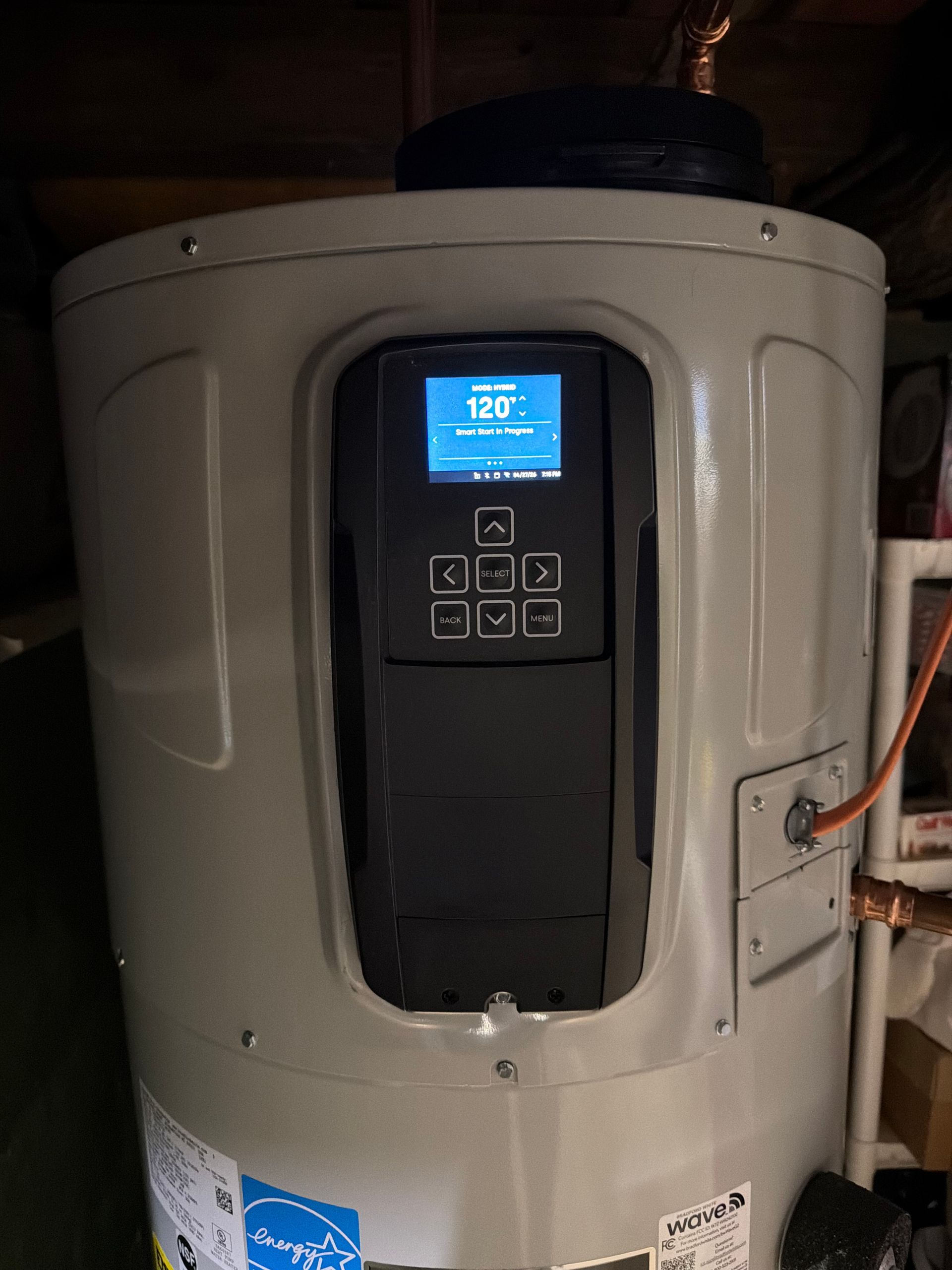 Tall beige water heater with a blue digital control panel in a utility room
